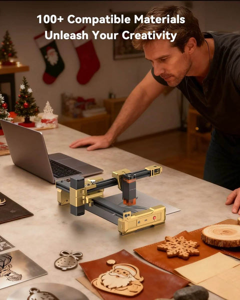 Artilume T1 foldable laser engraver on a workbench; gold-gray metal frame with rails beside wooden ornaments.