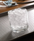 Heavy-Duty Commercial Nugget Ice Maker, Air Cooled Stainless Steel Exterior, Cranks Out Up To 343 Lbs Of Fresh Ice Daily, Boasts A Handily Sized Storage Bin, Countertop Ready - glass with nugget ice on a textured tray.