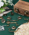 Old School Vintage Bail Pull Handles Set Of 10 In Antique Bronze For Cabinet Drawer Pulls And Cupboard Hardware Thirty Four By Ninety Two By Eight Point Five Millimeters Alloy Drop Drawer Pulls For Kitchen And Bedroom displayed with screws and wooden box on green surface.