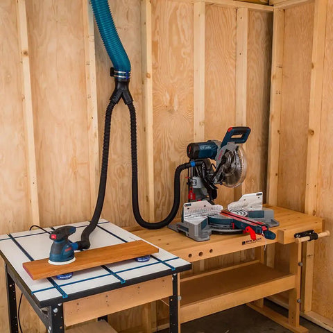 Workshop setup with 4 Inch To 2 Point 5 Inch Y Junction Dust Hose Splitter For Dust Collection Systems, attached to tools on a wooden workbench.
