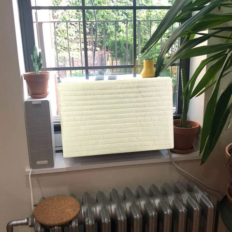 Legit Indoor Window Ac Cover That Keeps Your Setup Sharp And Shields Five To Seven Thousand Btu Units Fitting 21 By 15 By 3.5 Inches From Brisk Weather And Dust Builds Using Soft Washable Polyester In Crisp White on window unit with plants.