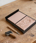 Starter Friendly Rubber Stamp Carving Kit With Carving Blocks And Metal Tools For Beginners Includes Linocut Tools And Printing Supplies To Create Custom Prints At Home Easy Block Printing Set For Crafters And Kids. Rubber blocks with carving tool and roller on workbench