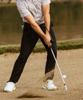 Golfer using Right Hand Golf Swing Training Aid That Improves Clubface Awareness, Swing Plane, And Impact in sand bunker