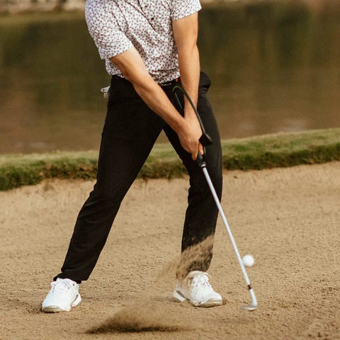 Golfer using Right Hand Golf Swing Training Aid That Improves Clubface Awareness, Swing Plane, And Impact in sand bunker