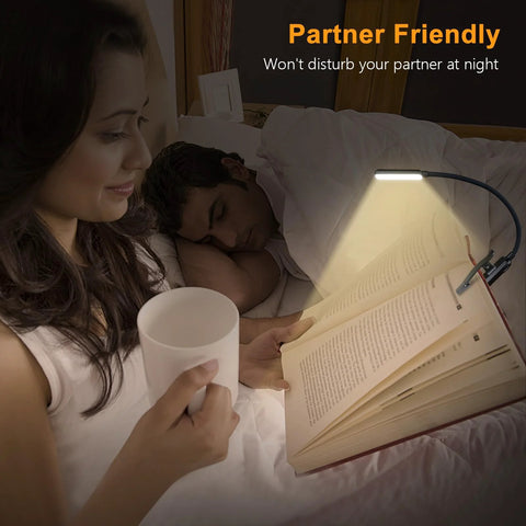 Gritin 9-LED rechargeable clip-on book light clipped to an open book on a bed, illuminating pages