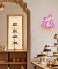 Cat-shaped neon sign and cake display in a cozy café setting