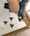 Person using a drill to install No Sweat Quick Install Furniture Panel Connectors For Cabinets And Wardrobes With Easy Push On Hardware.
