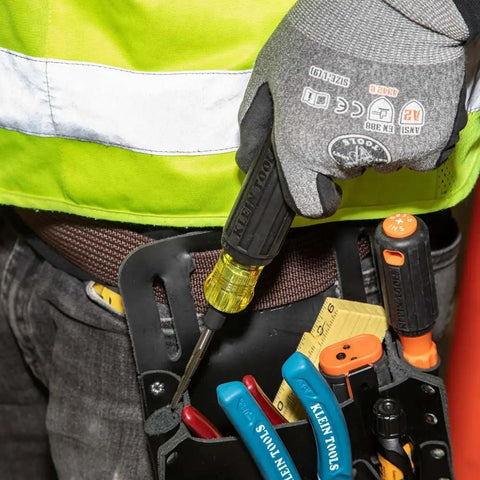 Person holding 6 In 1 Tapping Tool From Klein Tools With Cushion Grip for Repairing Threads, attached to tool belt