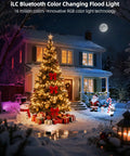 Outdoor LED Flood Light 80W 8000 Lumens Color Changing Smart Floodlight RGBW illuminating a decorated house and Christmas tree at night