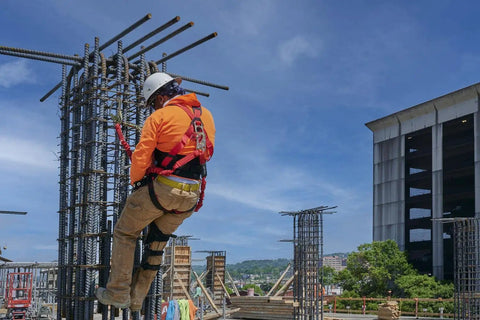 Worker on a construction site wearing Premium EagleLite Harness With Tongue Buckles And 3 Steel D Rings For All Day Fall Protection.