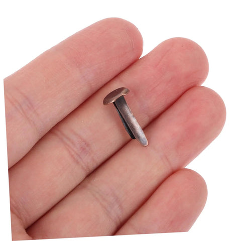 Close-up of a brown miniature metal brad from 50 Pack Miniature Metal Fasteners and Close Pins for Scrapbooking Card Making and Craft DIY Brads Paper Fasteners for Arts and Crafts Projects and Creative Kid Friendly Activities Easy to Use.