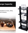 Large Capacity Cold Brew Coffee Maker Tower With 1000ml Vertical Glass Carafe And Solid Wood Stand on a countertop with beverage.