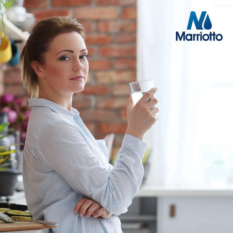 Person holding a glass of water in a kitchen, emphasizing fresh water provided by XWF Refrigerator Water Filter Replacement MR-XWF Model.