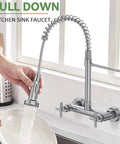 Rock Solid Wall Mount Kitchen Faucet With Smooth Dual Handles And No Fuss Two Function Spray For Laundry Or Commercial Sinks Built Tough From Lead Free Brushed Nickel Stainless Steel, shown in use with a pull-down spray for easy dish cleaning.