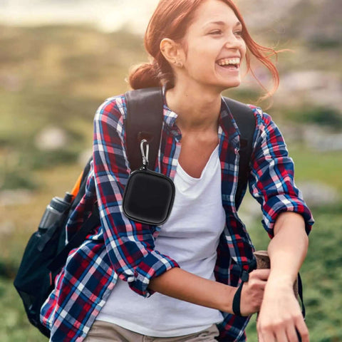 Woman outdoors with Built Kickass Mini Earbud Case With Steel Clip to keep your wireless headphones securely stashed.