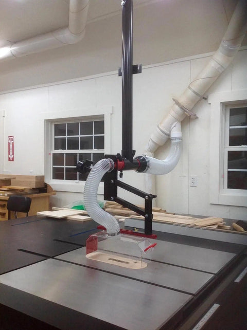 Heavy Hitter Table Saw Dust Collection Guard handles up to 16 inch blades with 45 degree tilting boom in workshop.