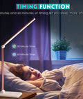 Game Changing LED Desk Lamp With Wireless Charger And USB Port by bed, illuminating dark room, pink model shown.
