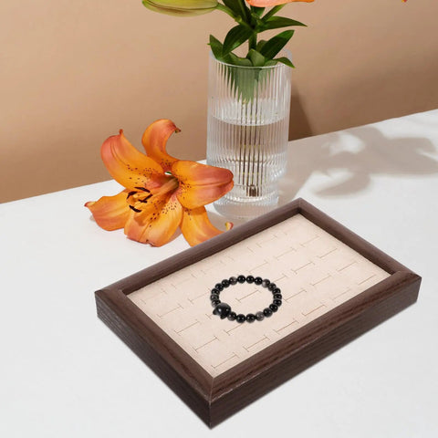 Solid Wood Earring Organizer And Ring Keeper Tray With Thirty Open Slots For Stashing Bracelets And Chains In A Rich Walnut Finish displaying a black bracelet.