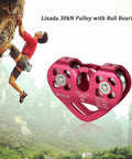 Climber ascending rock next to red 30KN double sheave pulley trolley for zipline with stainless steel bearings and alloy shell.