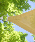 Corner of yellow Triangle Shade Sail Canopy 12x12x12 Ft Built Tough 200 GSM High Density Fabric For Patio Backyard Pool Outdoor Use with foliage