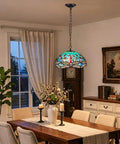 ARTZONE Antique Tiffany Pendant Light Fixture Stained Glass Hanging Lamp above a dining table with floral decor.