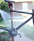 Person using a hose to clean a bike with a Bike Chain Keeper Holder For Cleaning And Lubing Wheel Dropout Chain Tensioner Tool installed.