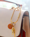 Dope Gold Brass Key Rings With Screw Lock Carabiner Clips For Keys And Handbags on a white purse.