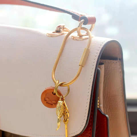 Dope Gold Brass Key Rings With Screw Lock Carabiner Clips For Keys And Handbags on a white purse.
