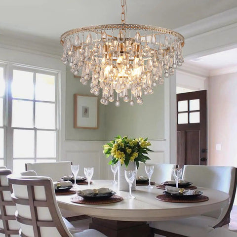 Gold Crystal Raindrop Chandelier Pendant Light For Dining And Living Rooms, 5 tier fixture hanging over a dining table.