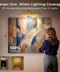Woman admiring artwork illuminated by Gold Wireless Picture Lights For Wall Art 2 Pack Rechargeable Wall Spots With Led Battery Screen Dimmable Gallery Bulbs.