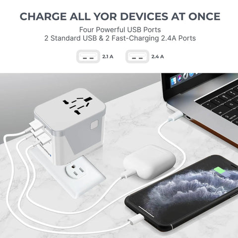 All In One No Fuss World Travel Adapter With 4 USB Ports Universal 120V Power Converter charging devices on a table