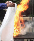 Person using Heavy Duty Fiberglass Fire Blanket 3.9 By 5.9 Feet For Emergency Survival And Kitchen Fire Safety on outdoor fire.
