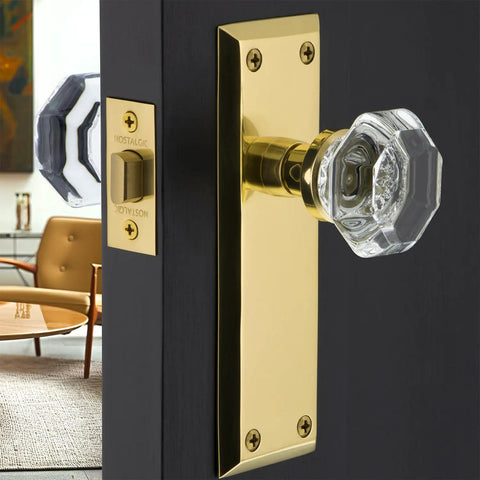 Crystal Door Knob With Plate In New York And Waldorf Style on a door, featuring a sleek clear knob and elegant brass back plate.