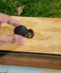 Installing Round Black Plastic Hole Plugs Kit on wooden furniture, covering a drilled hole, part of the 180 pcs set for furniture use.