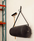 Tow Behind Poly Lawn Roller With Easy Turn Plug For Quick Fill And Dump 485 Lb Capacity hanging on wall with broom
