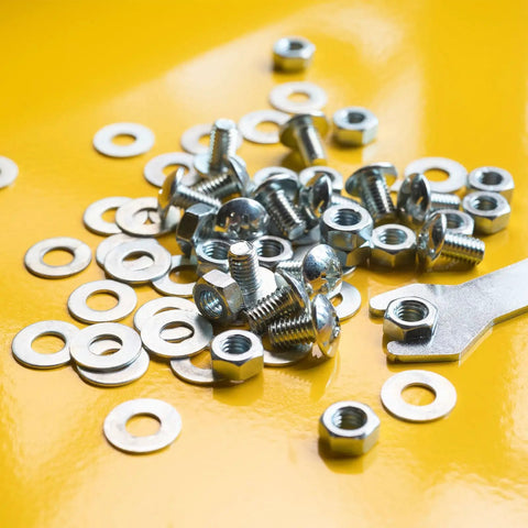 Real Deal Copper Flat Washers M22 25 Piece Set With Top Shelf Corrosion Resistance and Clean Edges scattered with nuts on yellow background.