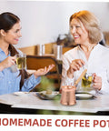 Two people enjoying drinks at a table with a Copper Turkish Coffee Pot With Wooden Handle For Quick Brew And Multi Purpose Beverage Kettle