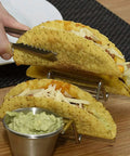 Hand placing tacos in Stainless Steel 3 Grid Taco Holder With V Shaped Slots And No Spill Sauce Cups, Oven Safe And Dishwasher Safe.