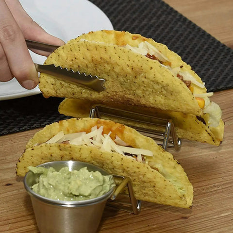 Hand placing tacos in Stainless Steel 3 Grid Taco Holder With V Shaped Slots And No Spill Sauce Cups, Oven Safe And Dishwasher Safe.