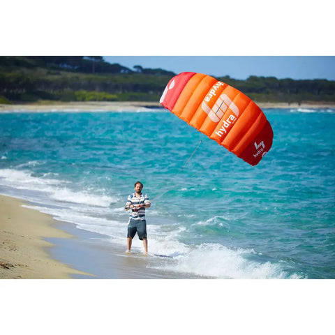 Person flying Hydra II Closed Cell Foil Water Trainer Kite 3 Meter at the beach, showcasing water relaunch and smooth power delivery.