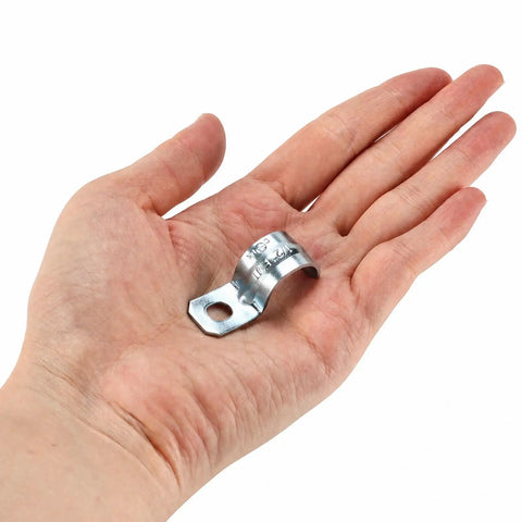 Heavy Duty One Hole 1/2 Emt Straps 100 Pack Zinc Plated Steel Conduit Clamps in hand, showcasing compact size for electrical tubing.