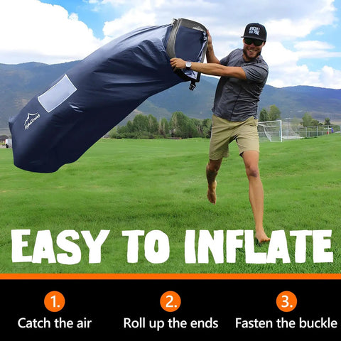 Man inflating Inflatable Lounger Beach Chair With Air Sofa Hammock For Camping And Backyard Hangout Ready Quick Inflate No Pump Needed Portable Couch By Lakeside Includes Compression Sack Durable Outdoor Gift For Adults on grass.