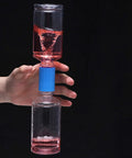 Hand holding Plastic Tornado Bottle Connectors Kit with Vortex Tubes, demonstrating red cyclone in bottles for science experiments