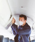Person on plane wearing Filtering Barrier Face Covering AFFM-5 One Size 5-Pack With Stretchable Side Bands For A Snug Fit.