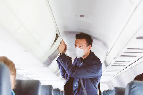 Person on plane wearing Filtering Barrier Face Covering AFFM-5 One Size 5-Pack With Stretchable Side Bands For A Snug Fit.