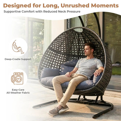 All Weather Two Person Egg Chair With Stand Cozy Oversized Wicker Hanging Loveseat Built Tough Steel Frame With Extra Thick Cushion Rain Cover Included Indoor Outdoor Patio Swing Chair Dark Grey with a person sitting on it