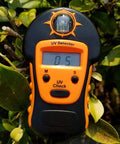 Portable Handheld Sun UV Detector For Measuring UV Levels Outdoors Easy To Use Sunlight UV Meter in foliage setting