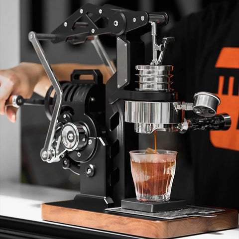 Level Up Your Coffee Game With This Dope Hand Cranked Espresso Machine Featuring Pro Grade 58mm Brewing Head And Adjustable Pressure Extraction For Silky Lattes And Cappuccinos At Home Or On The Road; close-up of manual espresso machine in action with glass cup underneath.