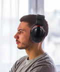 Man wearing Kick Loud Noise To The Curb With Double Layer Over Ear Earmuffs Designed For Construction Mowing And Shop Jobs.