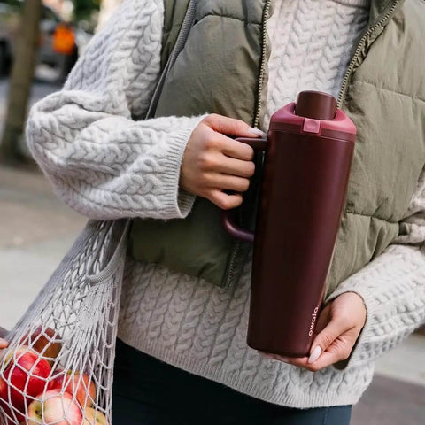 Person holding FreeSip Insulated Stainless Steel Tumbler With Built In Straw 40oz Side Handle Leak Proof in Black Cherry